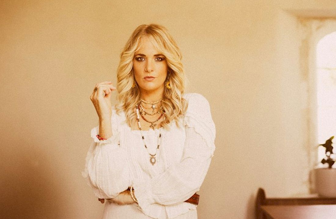 ELLES BAILEY Presents a Nurturing Narrative - photo © Rob Blackham - girl with red-amber hair in a white dress, standing against a white wall