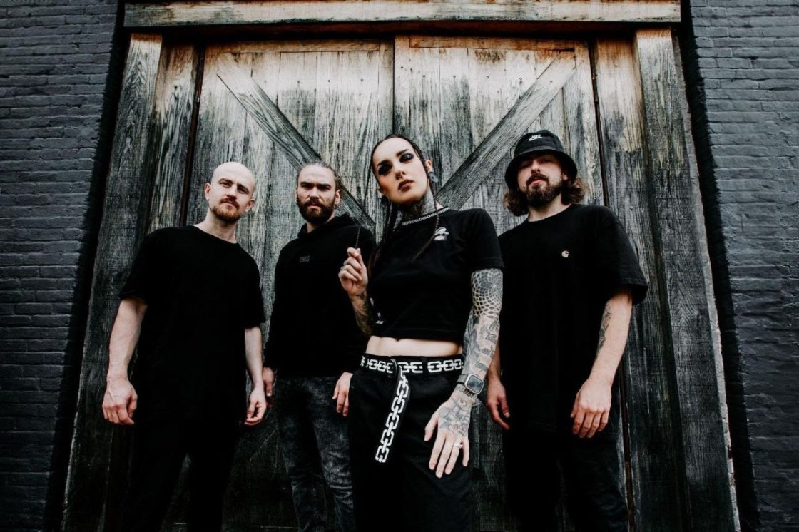JINJER UK Tour Dates - Photo Lina Glasir Band members dressed in black with female at front, set against large wooden door