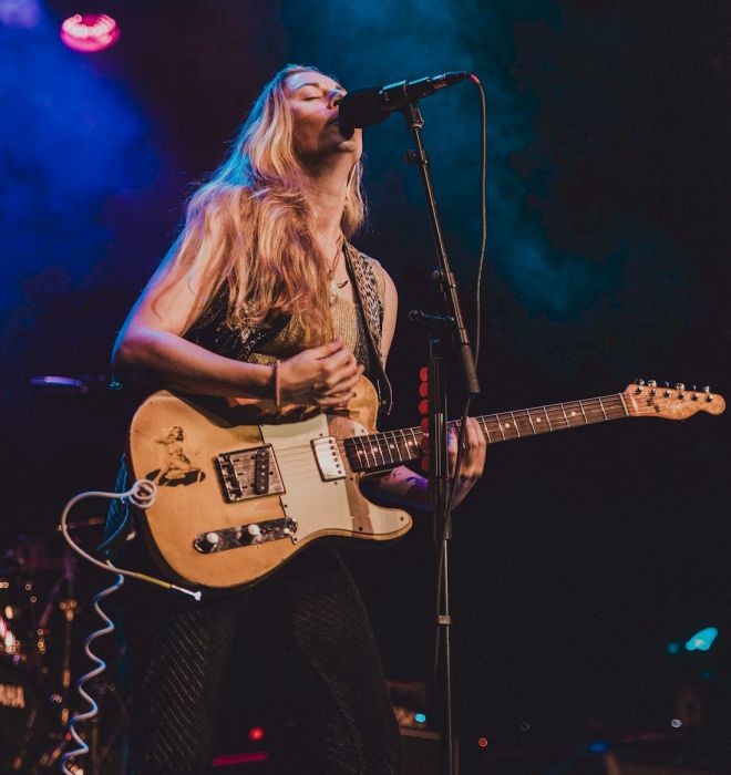 JOANNE SHAW TAYLOR Announces Trouble With Love - photo credit Szonja Neme - girl with long blonde hair holding a cream-yellow electric guitar