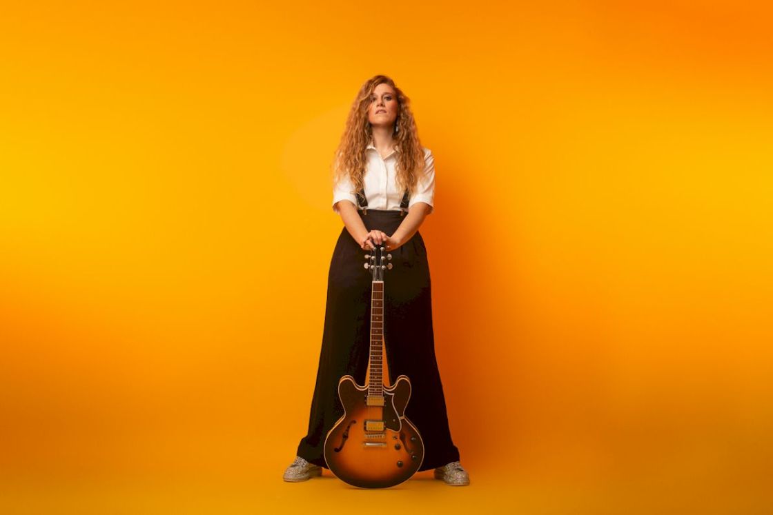 HOLLIE ROGERS Everything's Fine - photo credit Scott Chalmers - woman with long red hair holding a semi-acoustic guitar