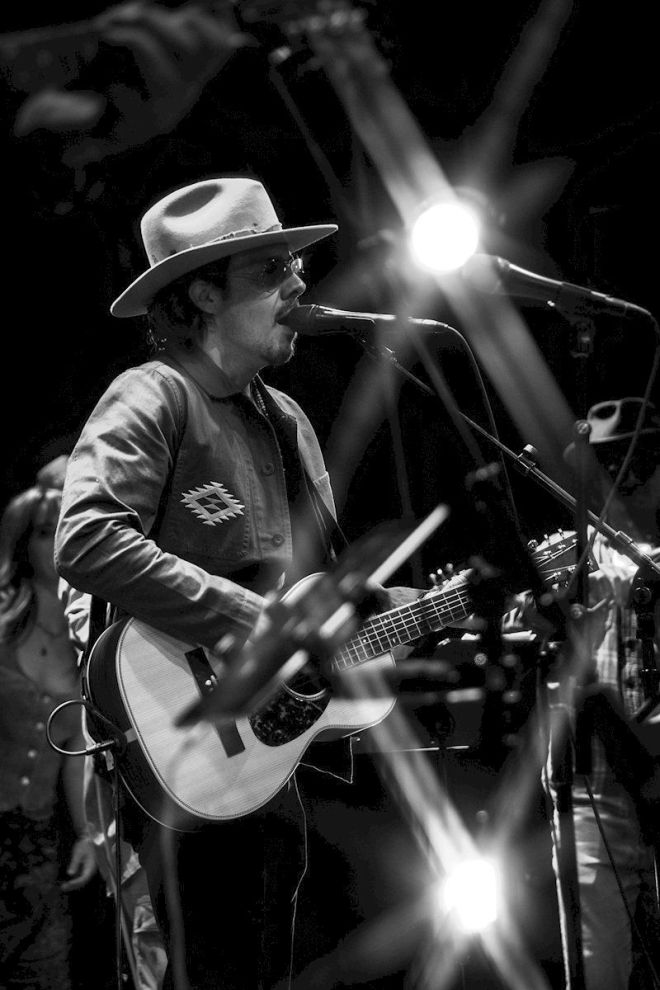 Brent Rupard EVERETTE Settling Down - photo credit Joe Randall - man with cowboy hat and guitar, on stage, singing into mic
