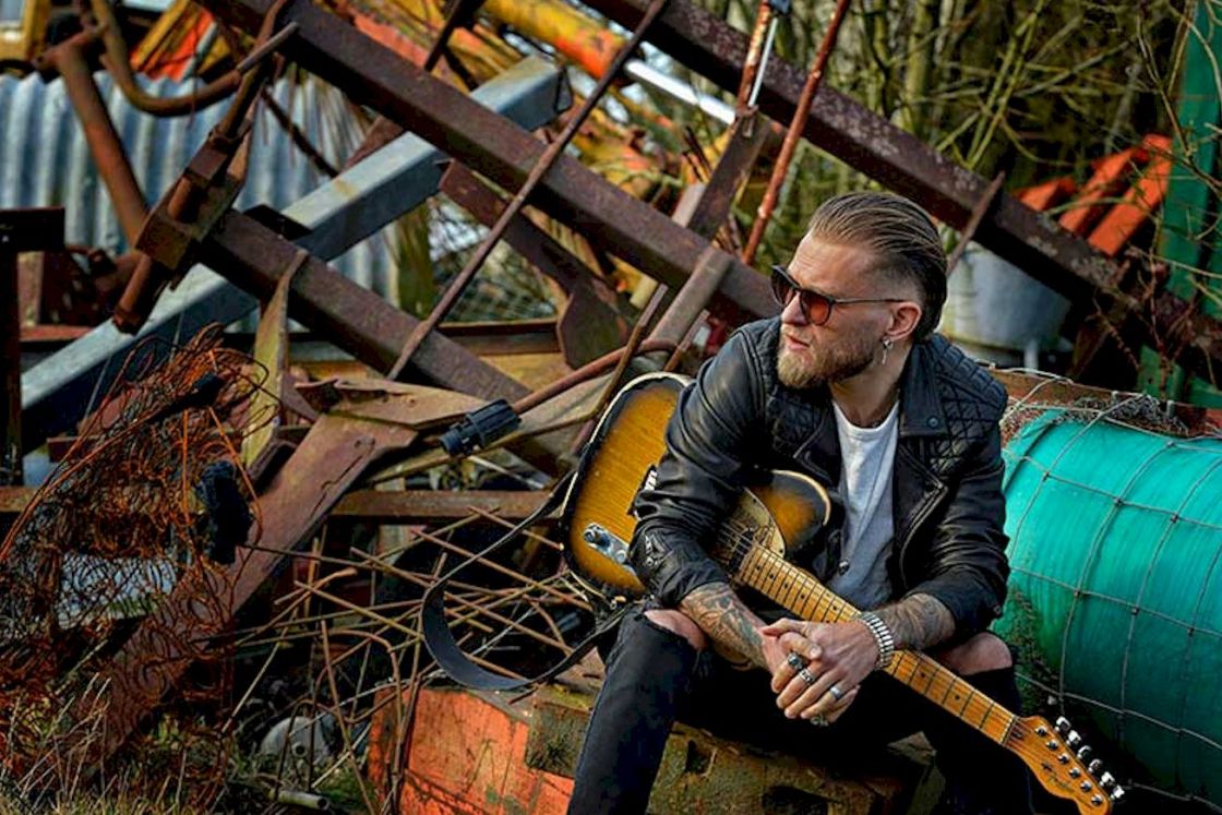 BEN POOLE Time Has No Mercy Photo Credit © Mike Inns - man holding guitar in scrapyard
