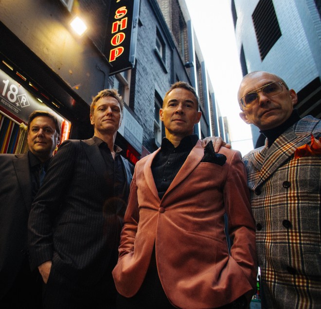 THE MILK MEN Give It Up - photo credit ROB BLACKHAM - four smartly dressed men standing outside club entrance