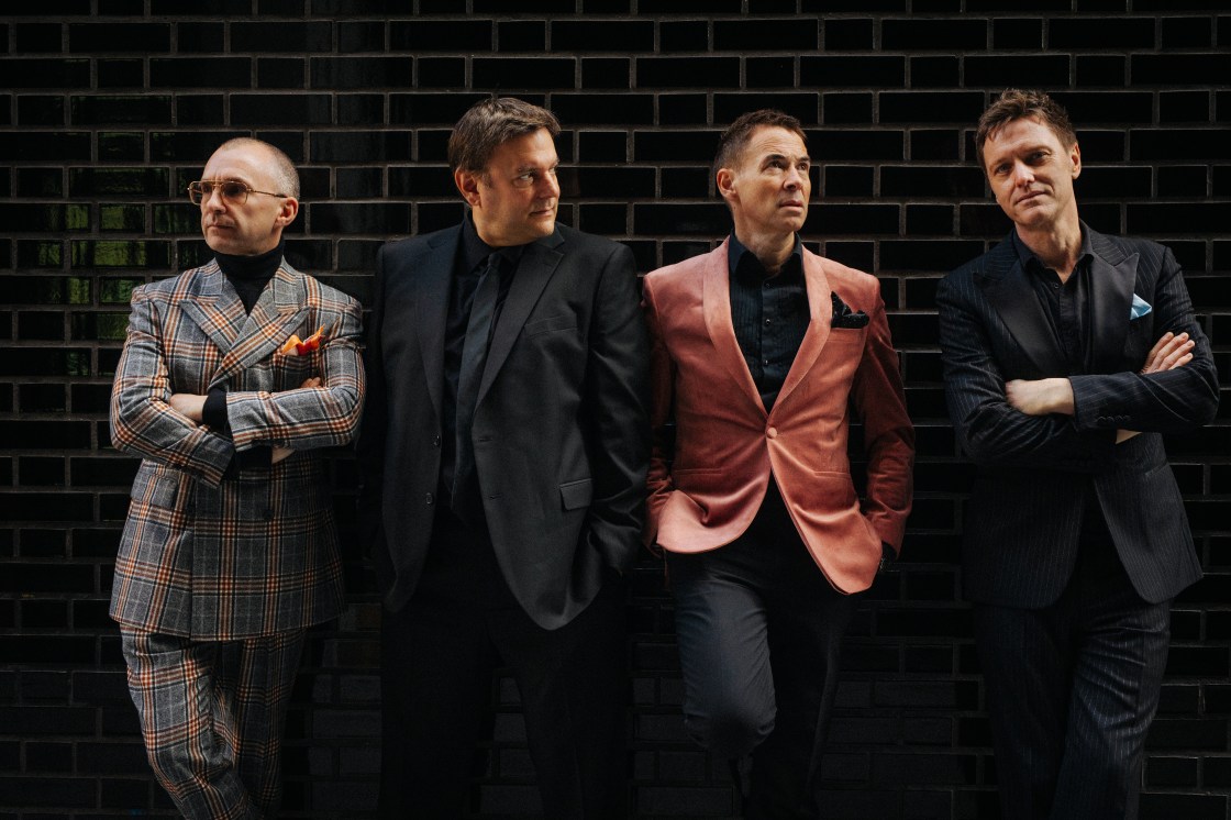 THE MILK MEN Give It Up - photo credit ROB BLACKHAM - four smartly dressed men standing with their backs to the wall