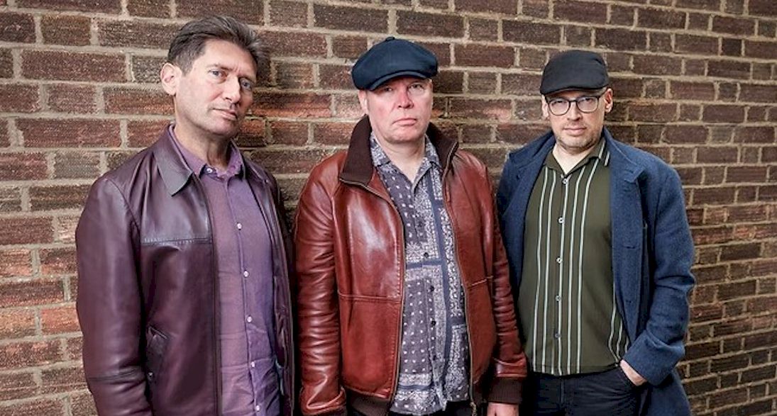 JIMMY REGAL AND THE ROYALS Snap Back - three white men standing by brick wall. Two men wear caps